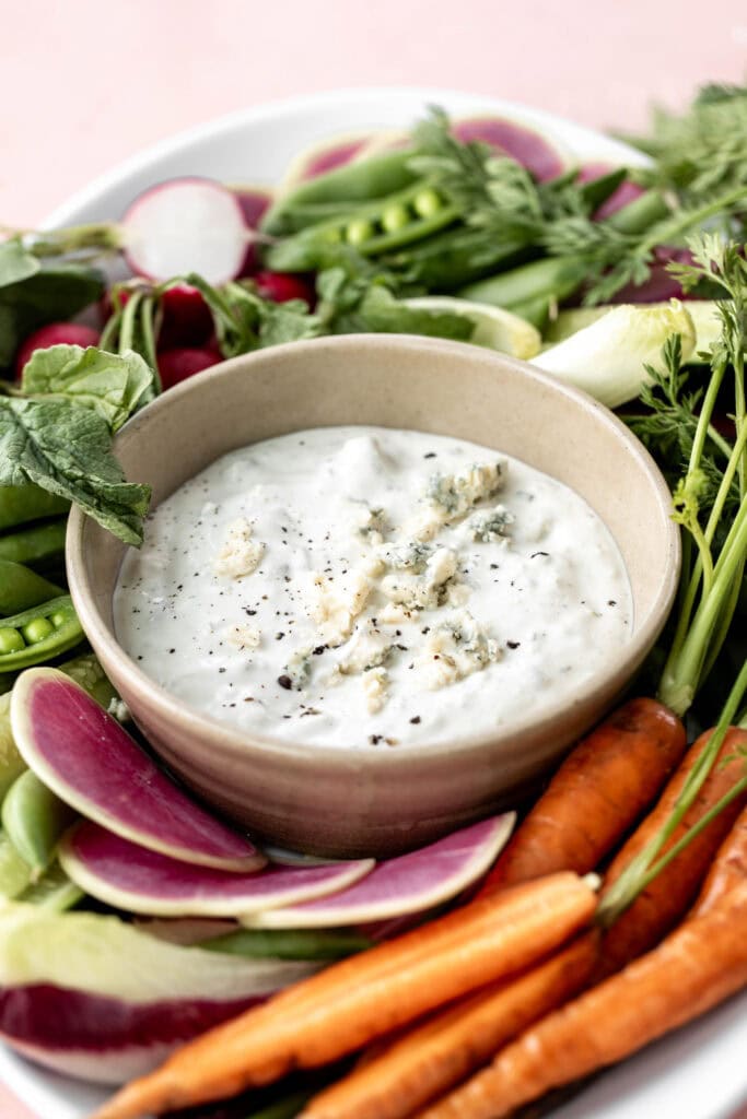 Side view of finished blue cheese dip with fresh vegetables for dipping.