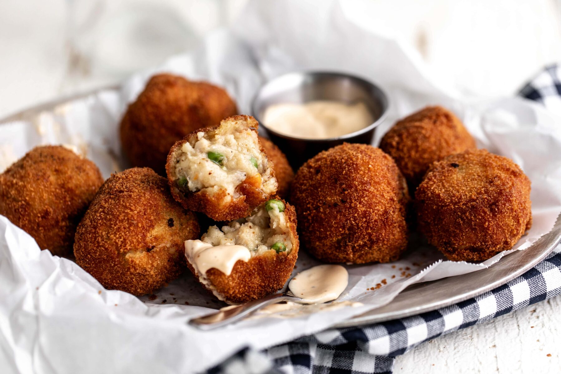 chicken pot pie croquettes opened with sauce for dipping.
