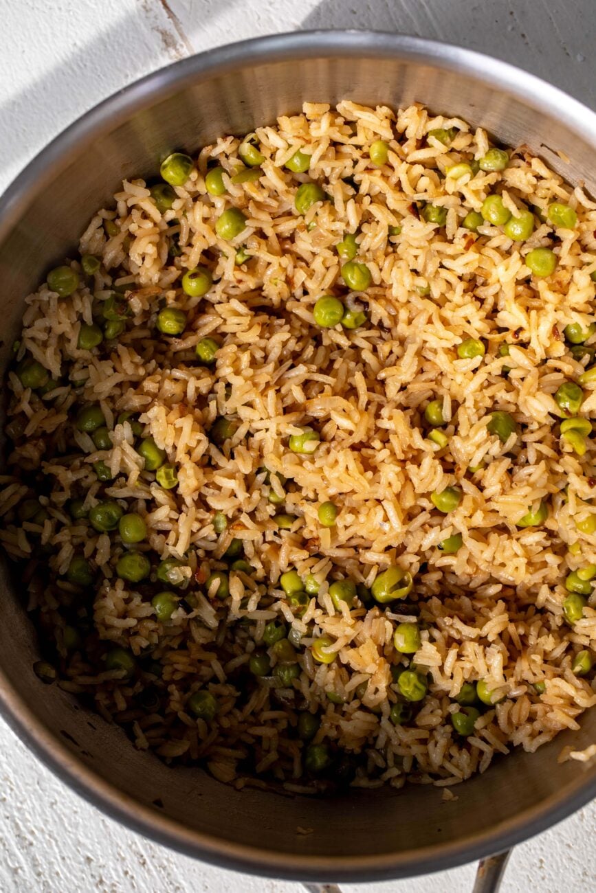 Cooked rice pilaf with peas and pistachios in pot. 