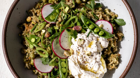 Green spring rice pilaf with pistachio and pesto burrata ready for serving.