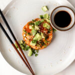 salmon tartare with diced avocado and green onion with chopsticks and soy sauce.
