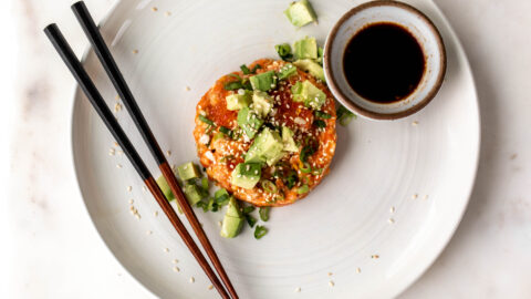 salmon tartare with diced avocado and green onion with chopsticks and soy sauce.