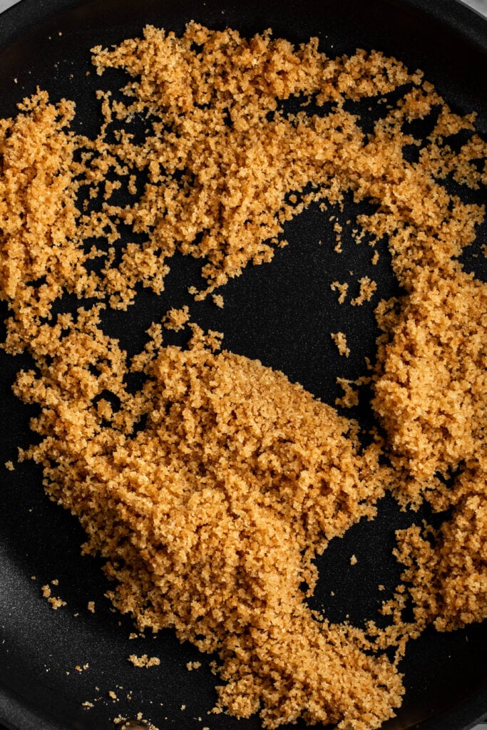 golden brown toasted breadcrumbs in black nonstick pan.