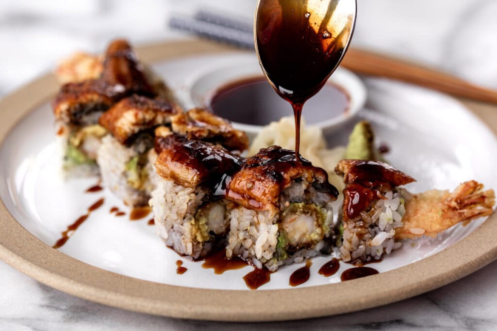 homemade eel sauce drizzled over a shrimp tempura and eel sushi roll.