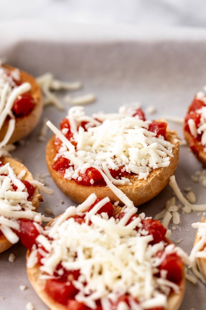 mini bagels topped with pizza sauce and shredded mozzarella cheese.