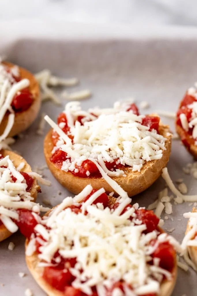 mini bagels topped with pizza sauce and shredded mozzarella cheese