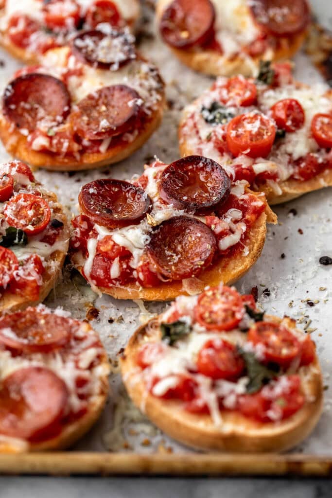 broiled pizza bagel bites garnished with parmesan cheese.