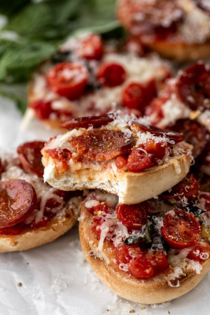 Finished pizza bagel with bite taken out.