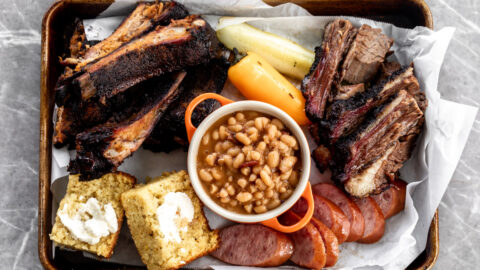 best baked beans recipe in small pot with bbq ribs cornbread and brisket.
