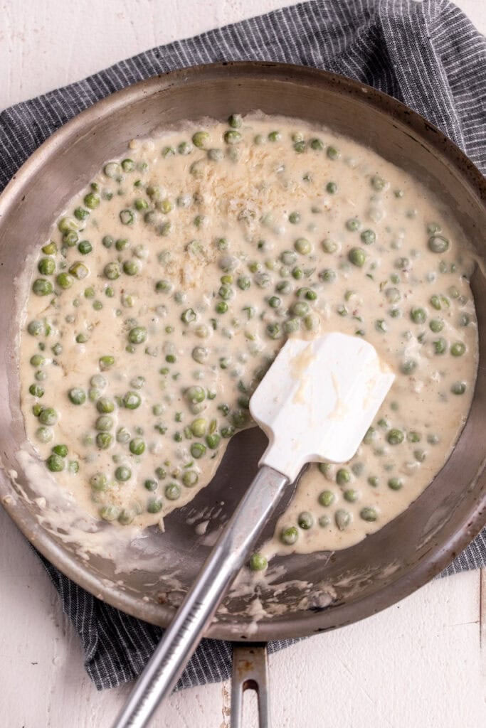 easy alfredo sauce in pan with peas.