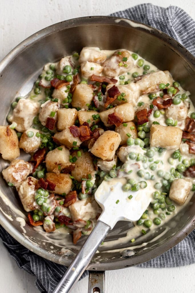 cauliflower gnocchi with bacon and easy Alfredo sauce and peas.