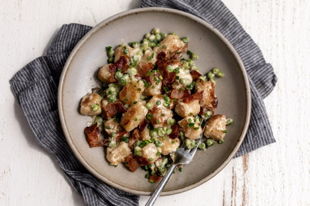 cauliflower gnocchi with bacon and easy Alfredo sauce and peas.