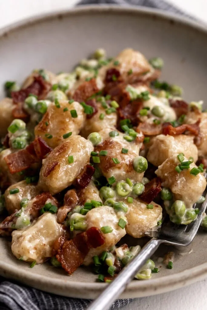 cauliflower gnocchi with bacon and easy Alfredo sauce and peas.