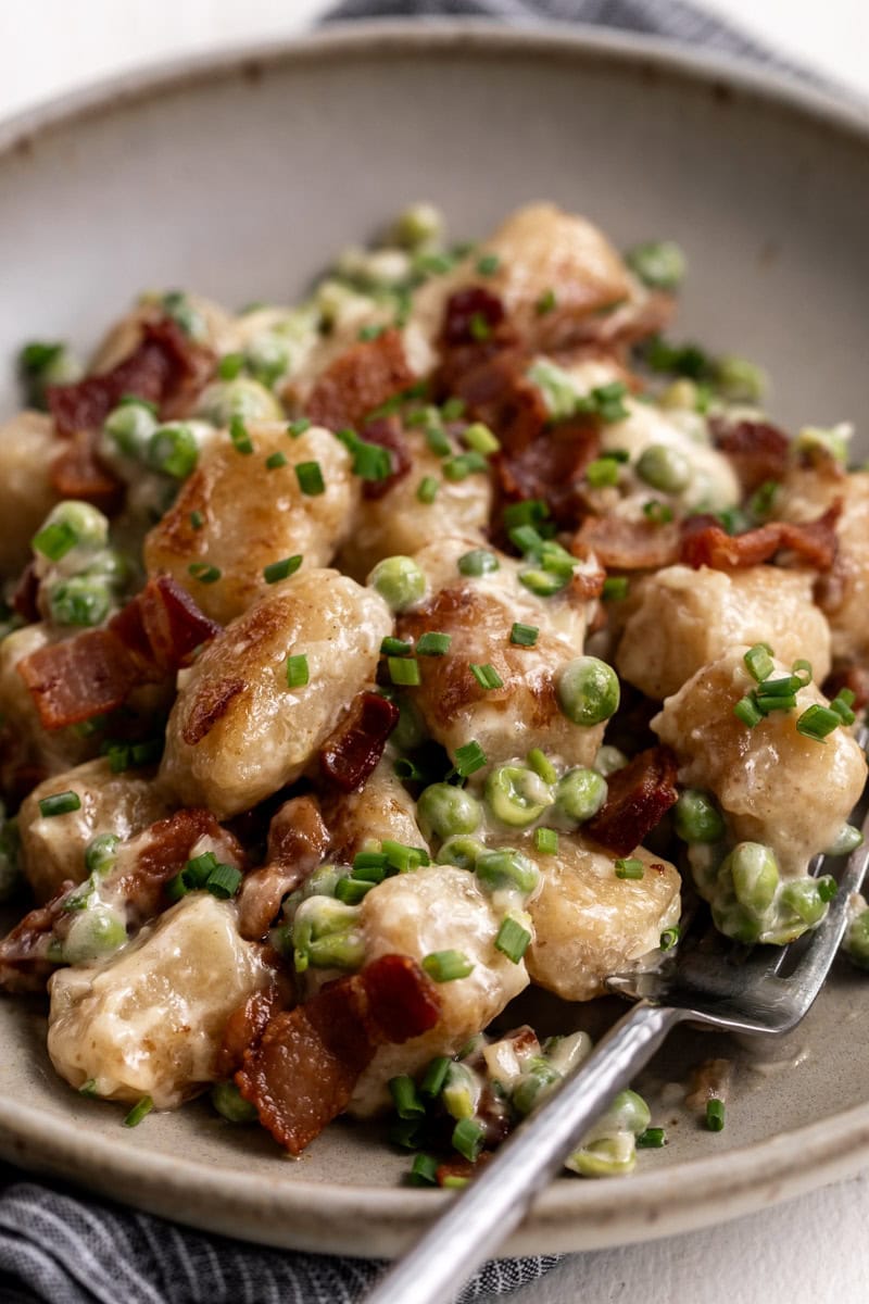 cauliflower gnocchi with bacon and easy Alfredo sauce and peas.