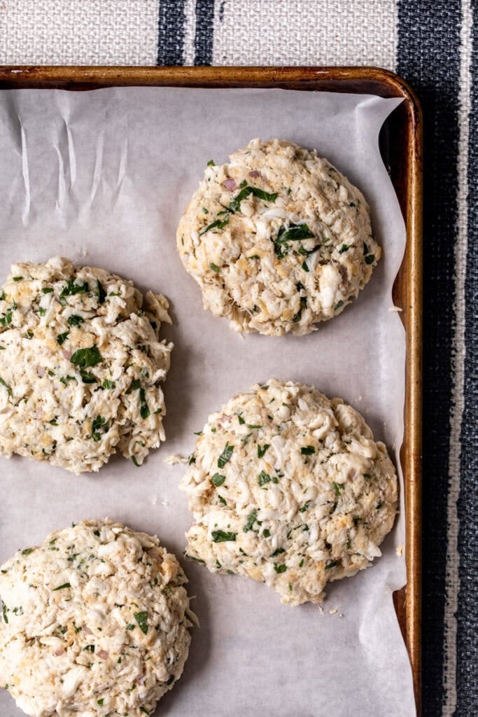shaped crab cakes on baking sheet.