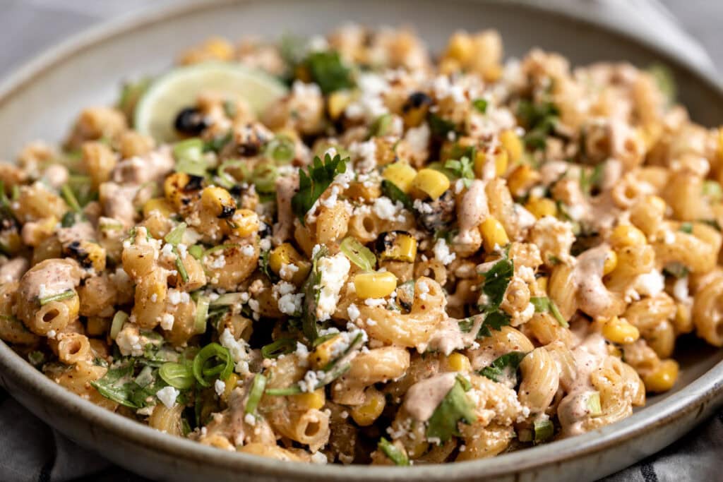 mexican street corn pasta salad esquites with lime wedge.