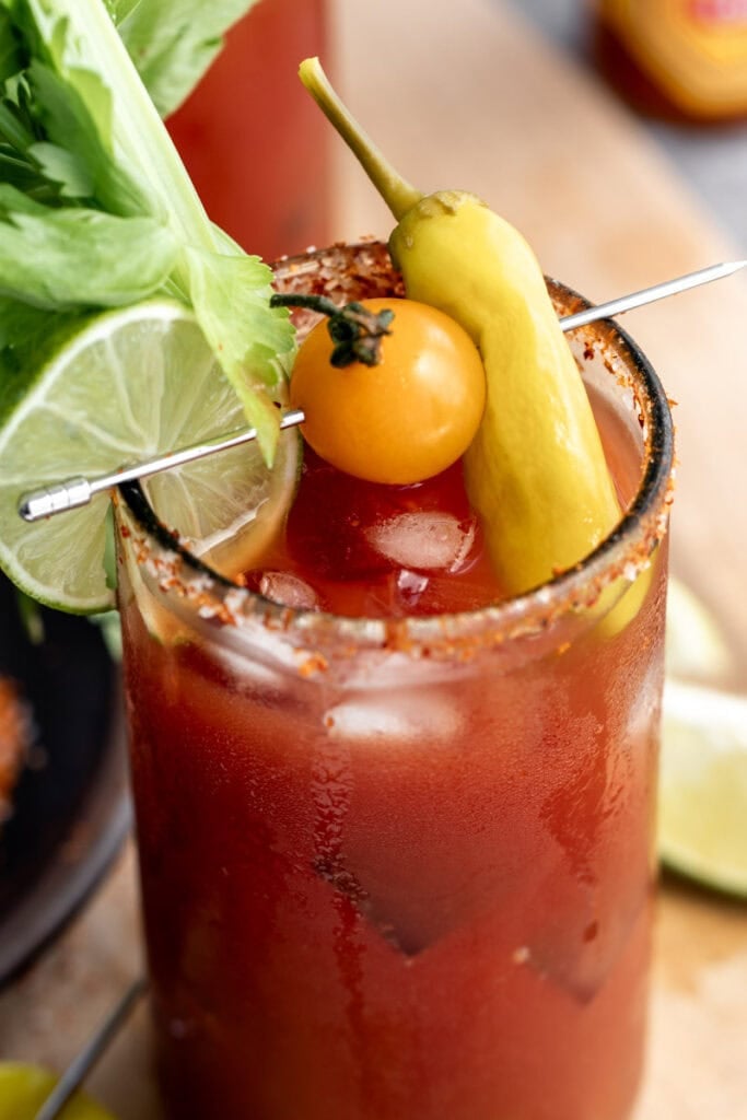 mezcal bloody maria garnished with tomato and pepperoncini pepper.