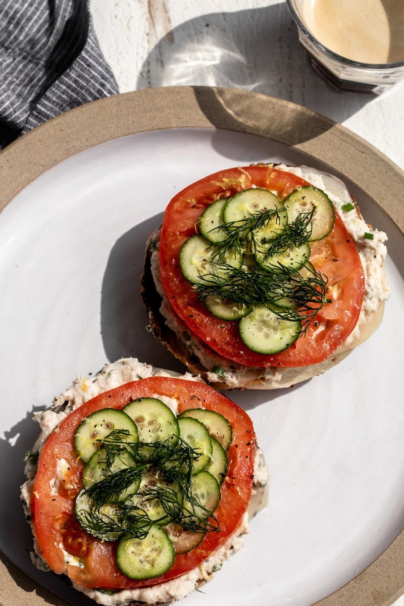 whitefish salad bagel with tomato slice, cucumber and dill.