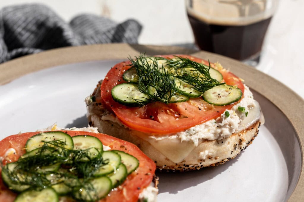 whitefish salad on everything bagel with tomato slice, cucumber and dill.