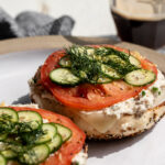 whitefish salad on everything bagel with tomato slice, cucumber and dill.
