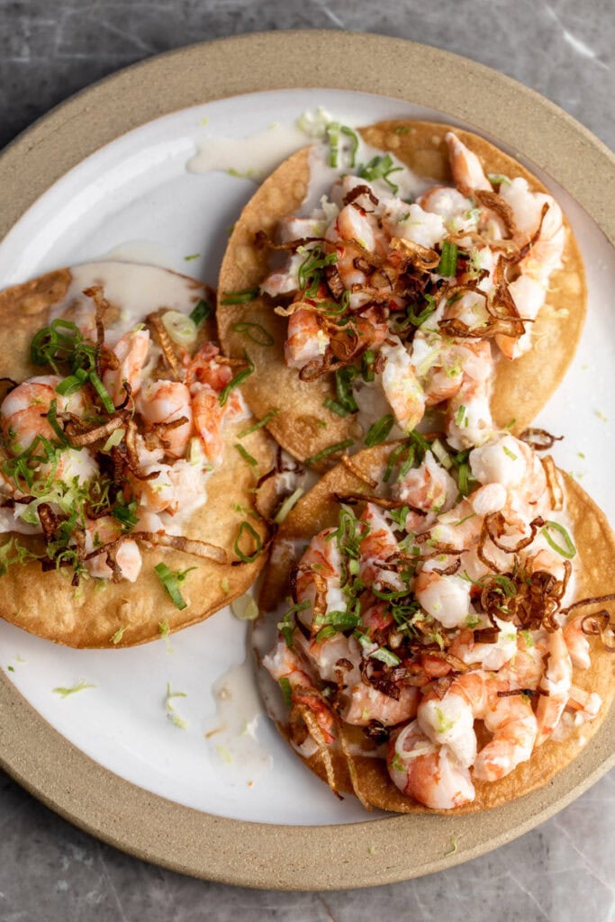 coconut shrimp ceviche tostadas with crispy fried shallots garnished with lime zest.