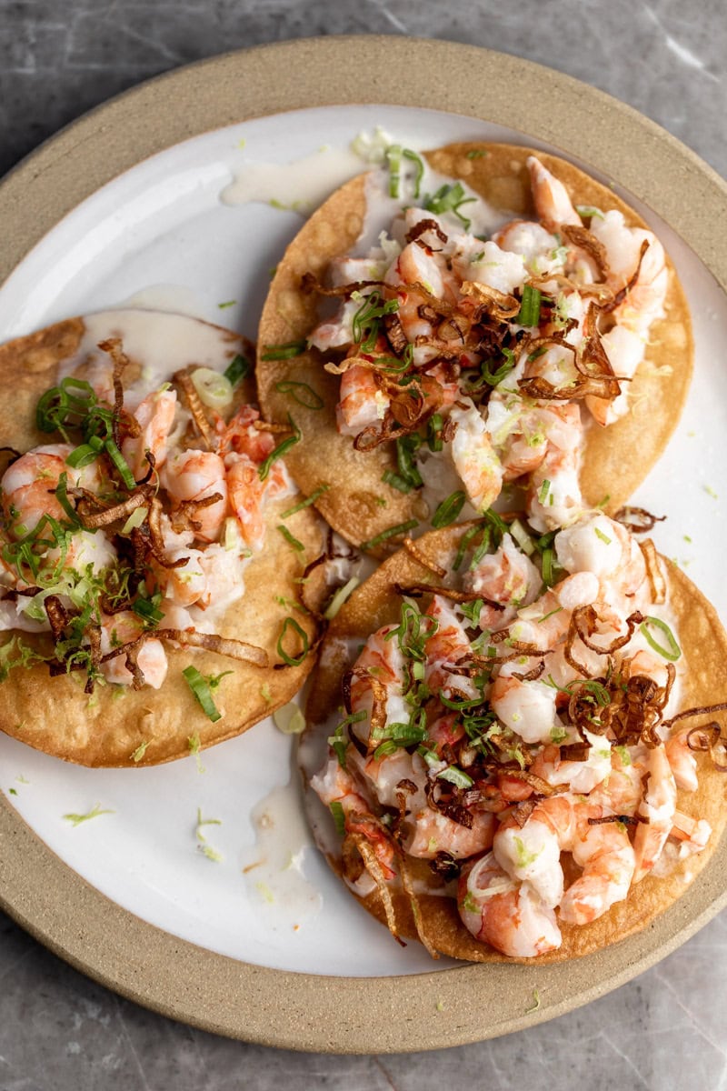 coconut shrimp ceviche tostadas with crispy fried shallots garnished with lime zest.
