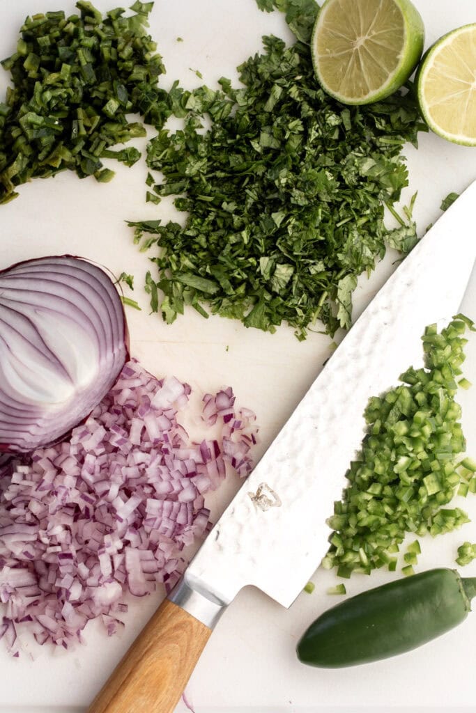 diced ingredients on cutting board for fresh corn salsa.