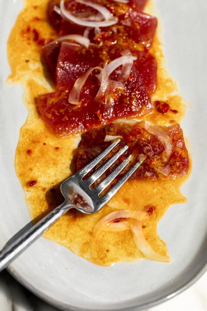 served Orange Calabrian Chili Tuna Crudo on fork.