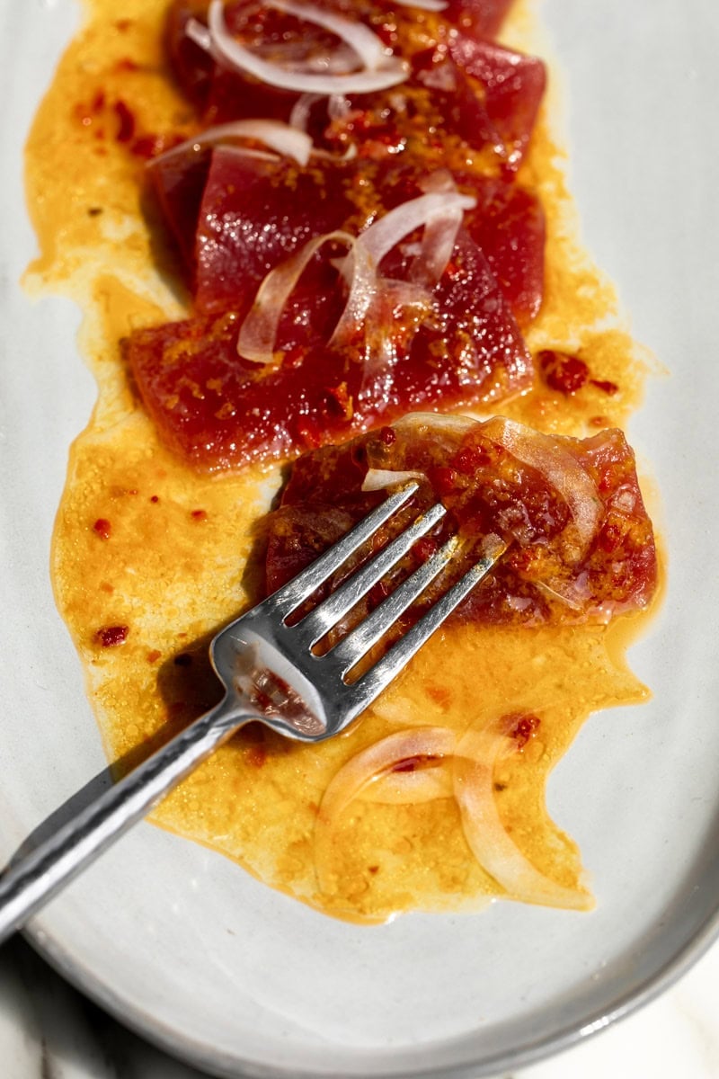 served Orange Calabrian Chili Tuna Crudo on fork.
