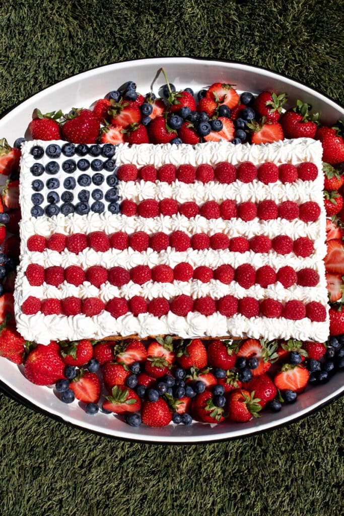 red white and blue flag cheesecake with berries and whipped cream.