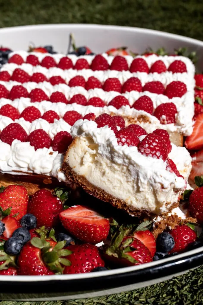 red white and blue flag cheesecake with berries and whipped cream slice closeup