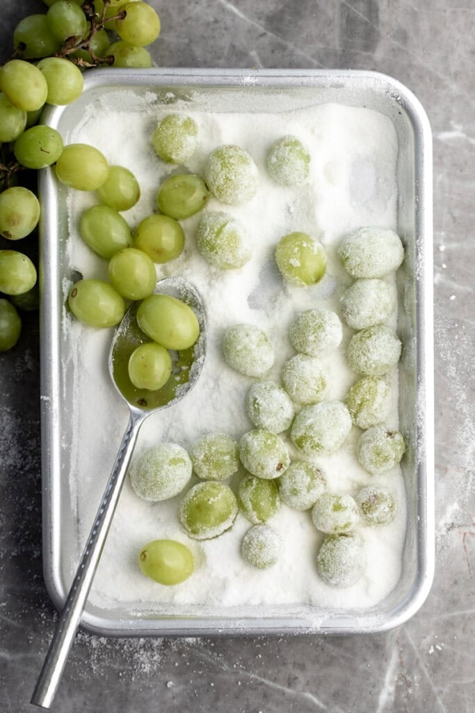 green grapes tossed in sugar mixture on baking sheet.