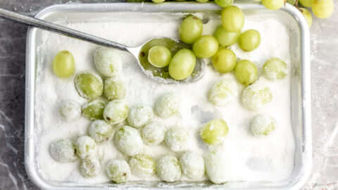 sour candied grapes on baking sheet in sugar