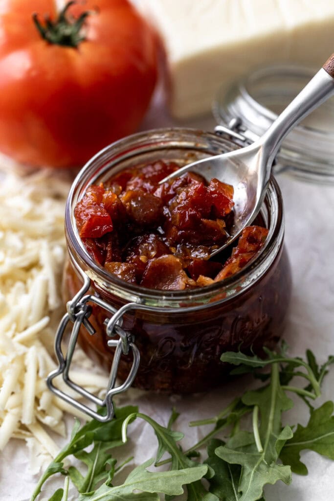 tomato bacon jam in glass mason jar with spoon.