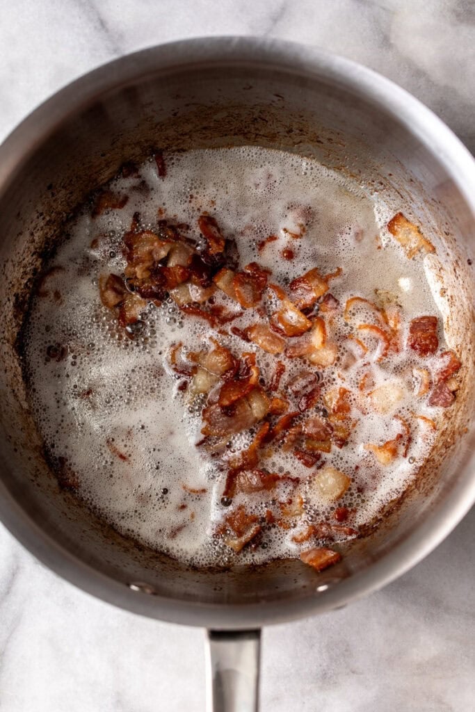 diced bacon cooked until crispy in pan.