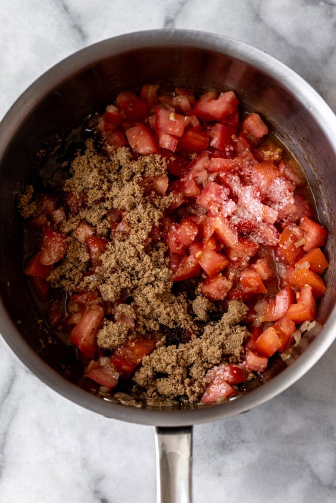 diced tomatoes in sauté pan for tomato bacon jam.