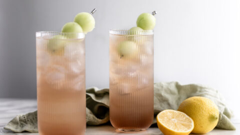 honey deuce cocktail with melon balls and halved lemons.