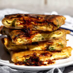 scallion pancake bacon egg and cheese sandwich with a drizzle of chili crisp.