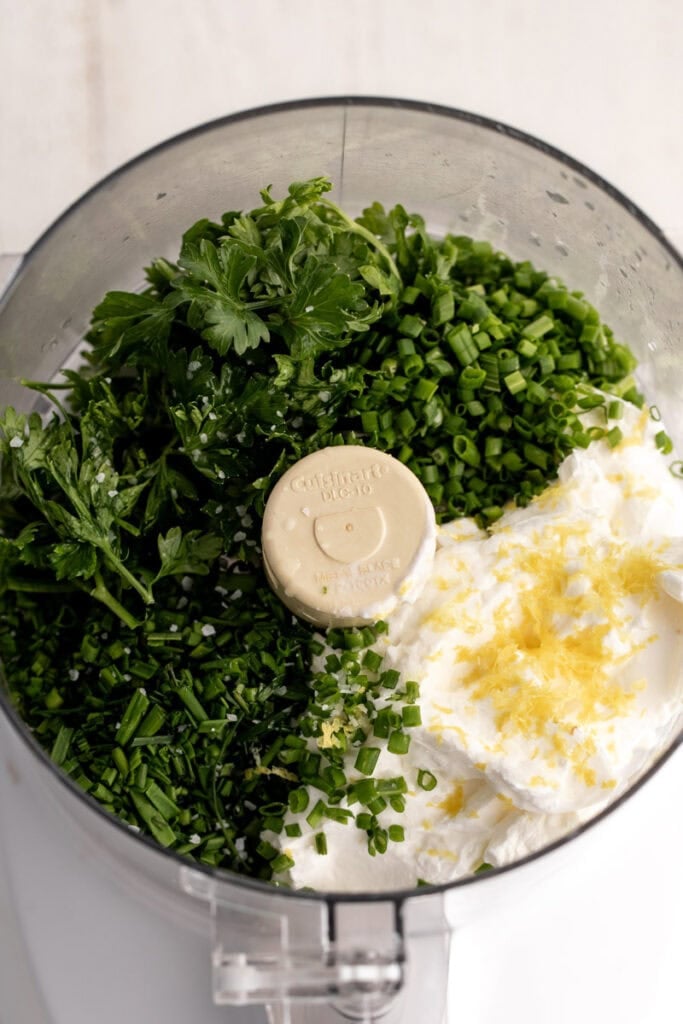 sour cream sauce ingredients herbs and lemon zest in food processor.