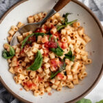 4 ingredient no cook easy tomato sauce over ditalini with basil leaves.