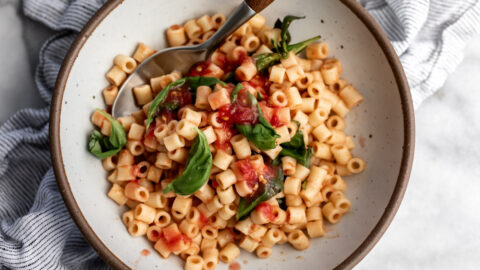 4 ingredient no cook easy tomato sauce over ditalini with basil leaves.