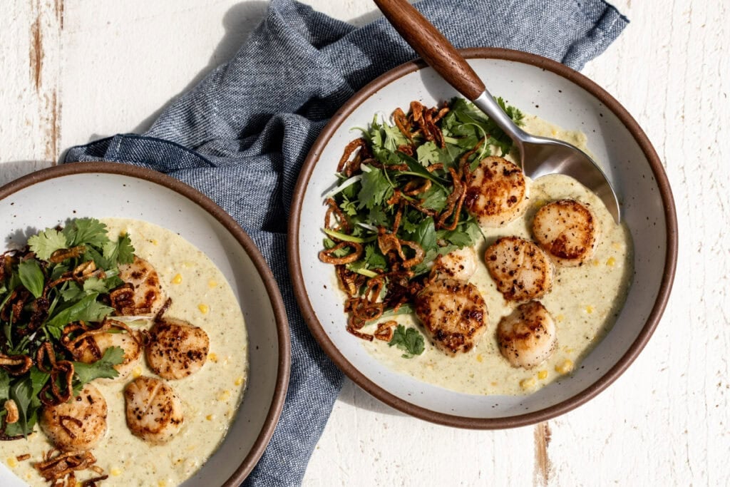 Green Curry Scallops with Corn topped with cilantro herb salad and fried crispy shallots.