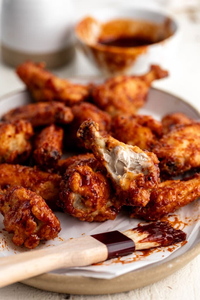 maple chipotle chicken wings with bite out of drumstick.