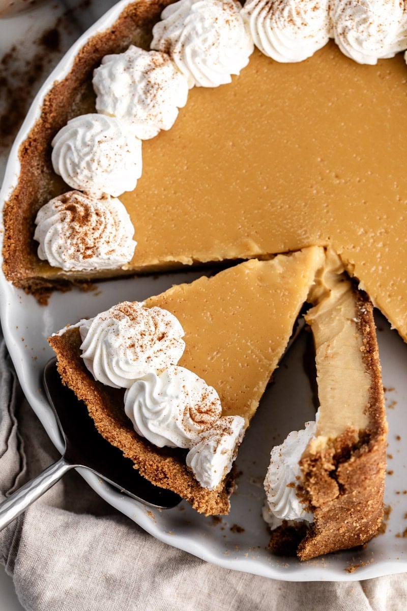 maple cream pie sliced with whipped cream garnished with cinnamon.