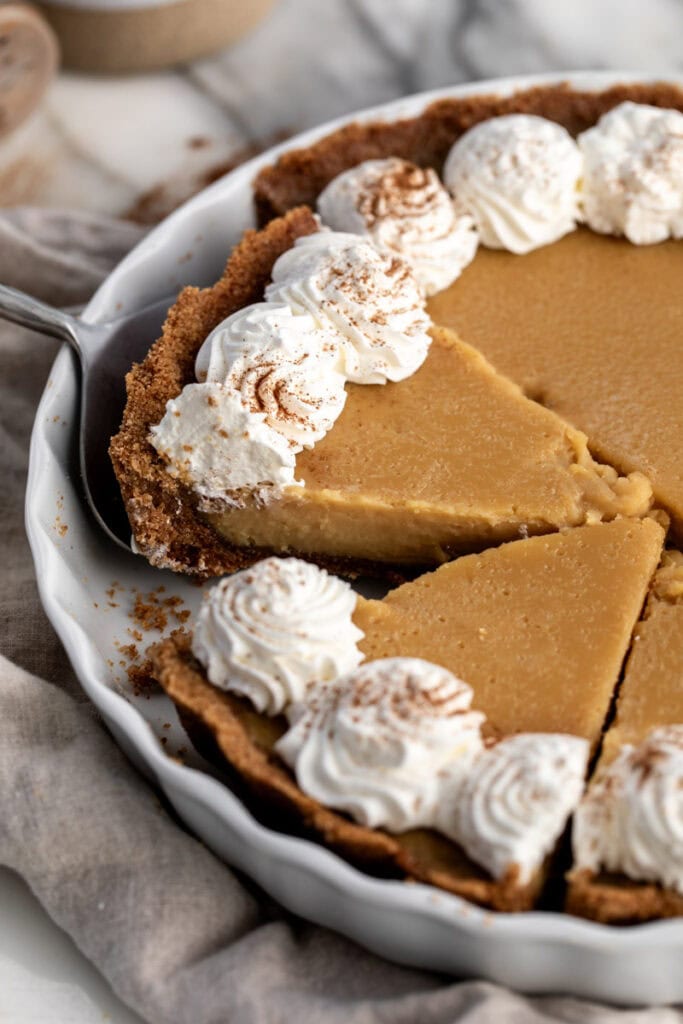 maple cream pie sliced in baking dish garnished with whipped cream.