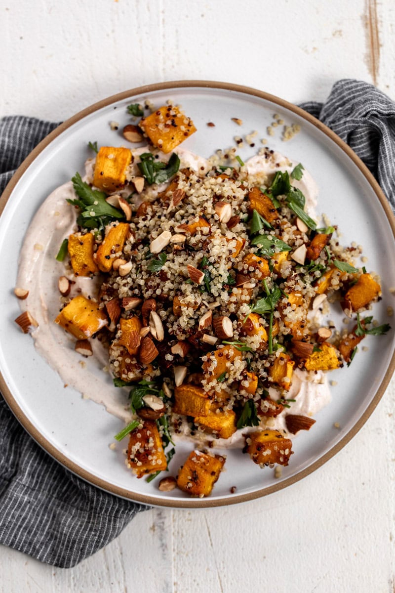 roasted pumpkin and quinoa salad with spiced yogurt topped with almonds.