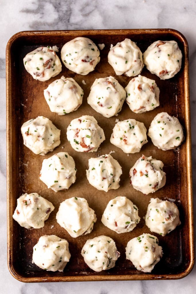 mashed potato croquette balls on baking sheet.