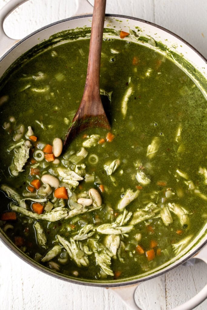 green minestrone soup with wooden spoon.