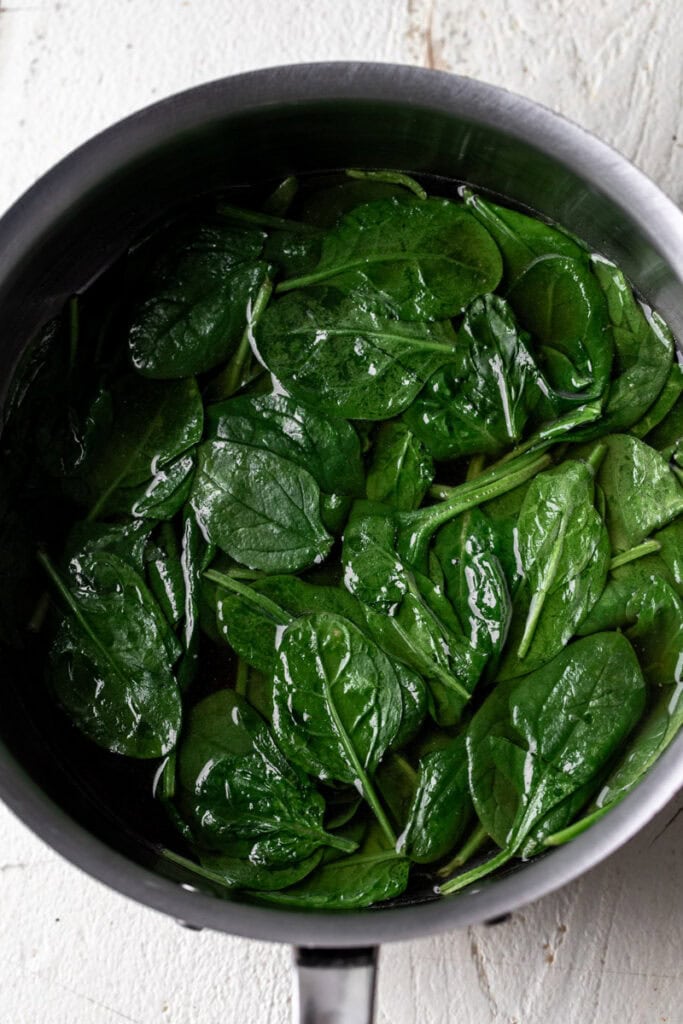 cooked baby spinach in pot.
