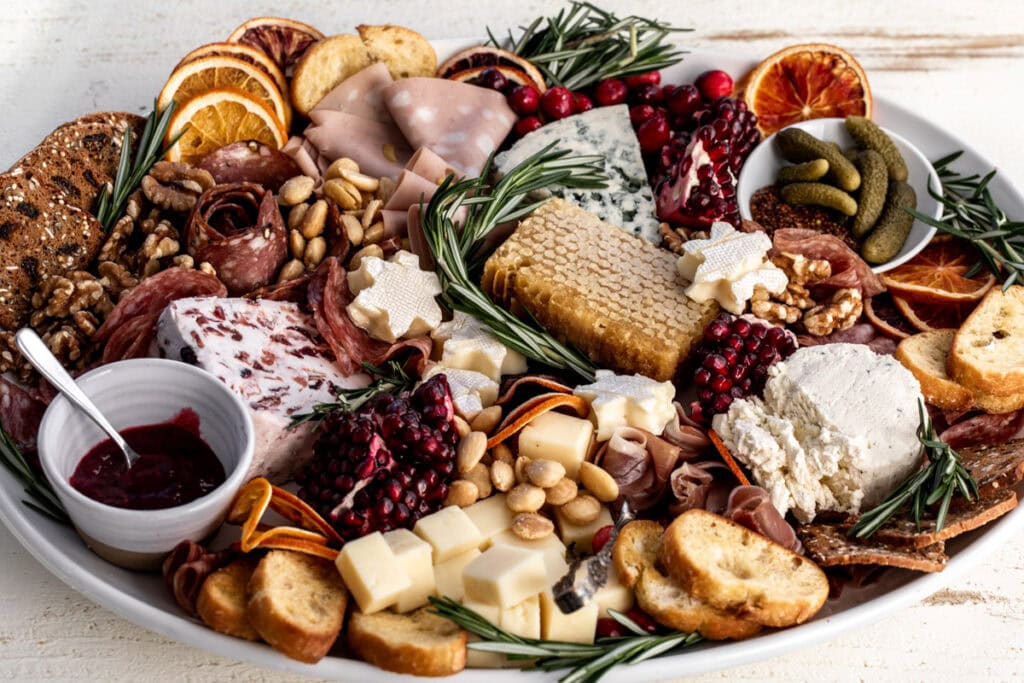 festive holiday cheese board with assorted cheese and charcuterie.